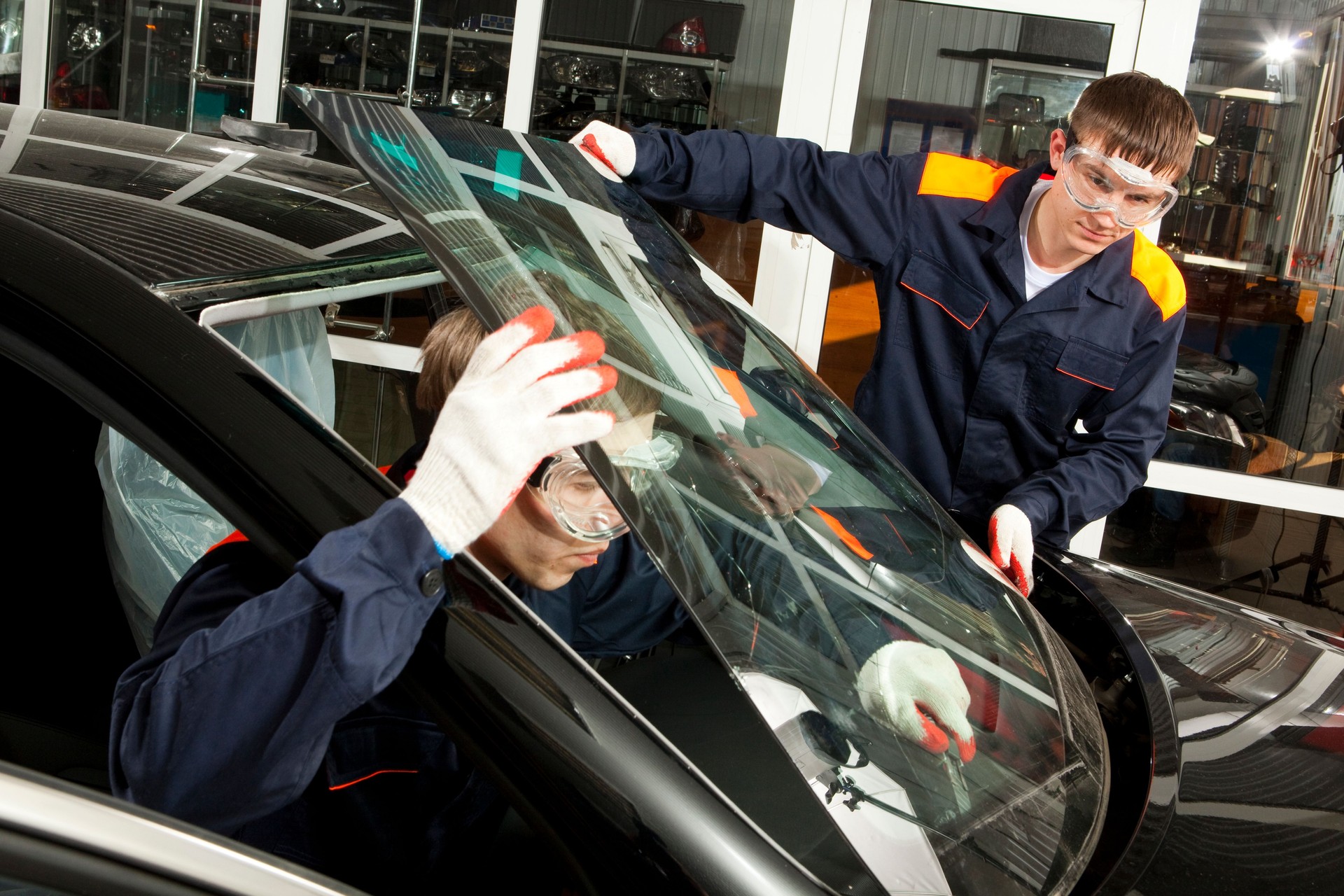 Two Real Mechanics working  in Auto Repair Shop.