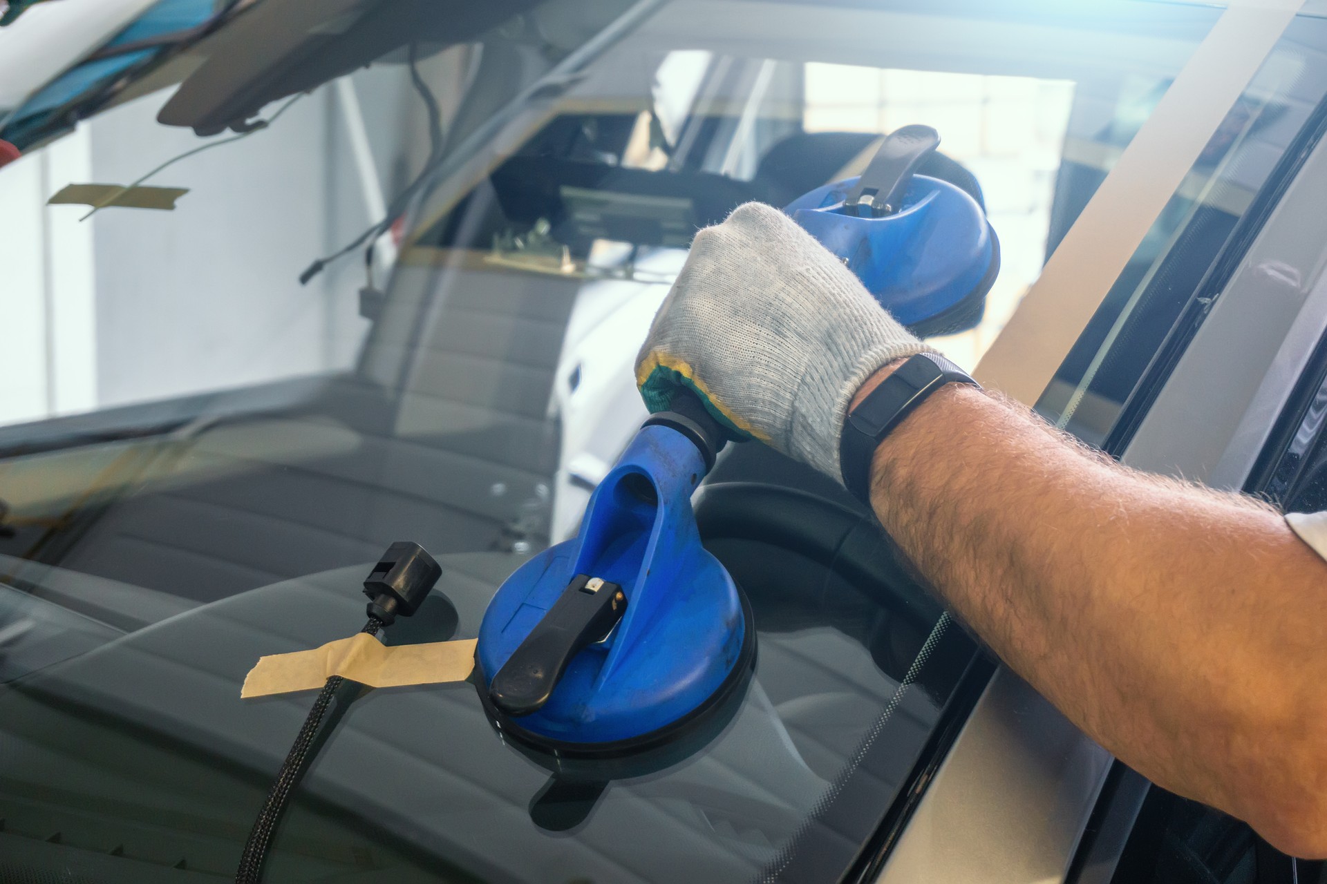 Mechanic changes windscreen or windshield on car close up